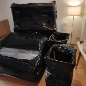 Sorgfältig mit schwarzer Stretchfolie verpackte Möbelstücke für einen sicheren Transport durch Swift Umzug Berlin